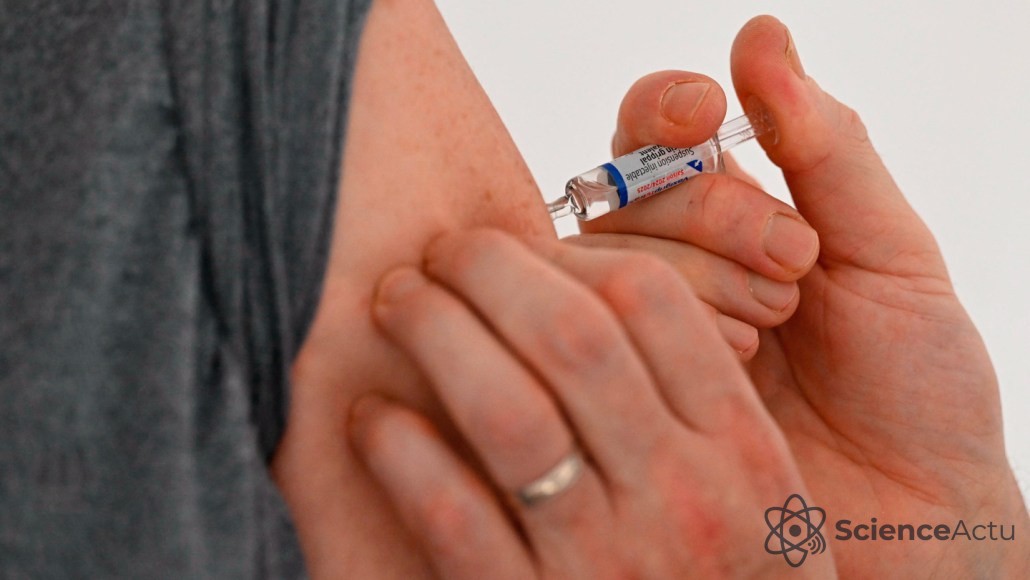 Une personne reçoit un vaccin contre la grippe dans le haut du bras par un professionnel de santé