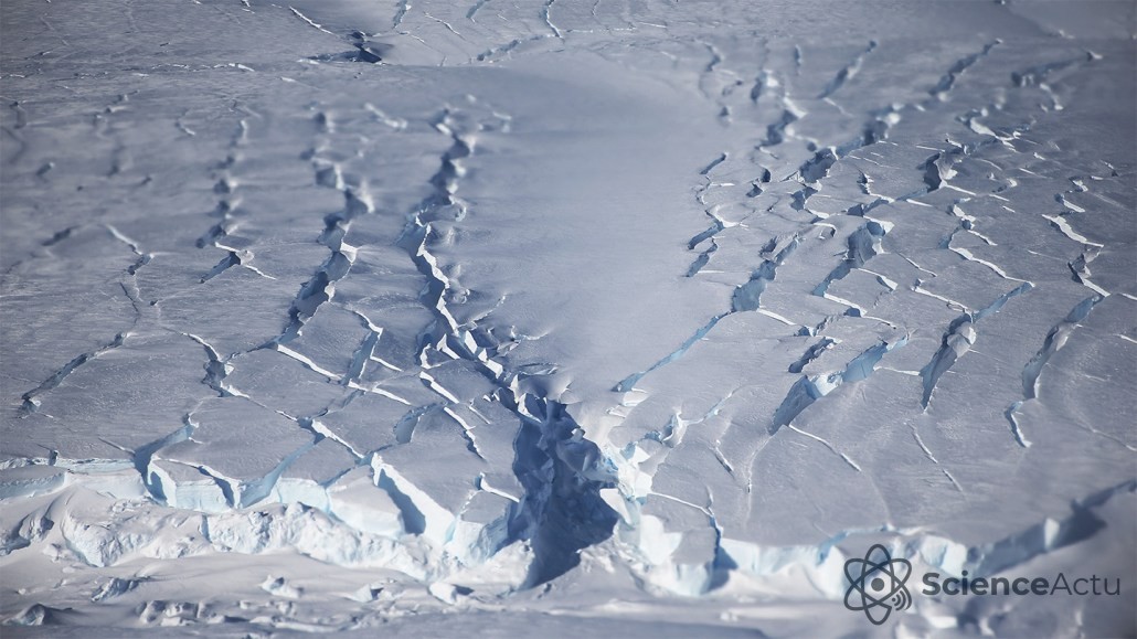 Vue aérienne d'une calotte glaciaire montrant une vaste étendue de glace blanche et craquelée.