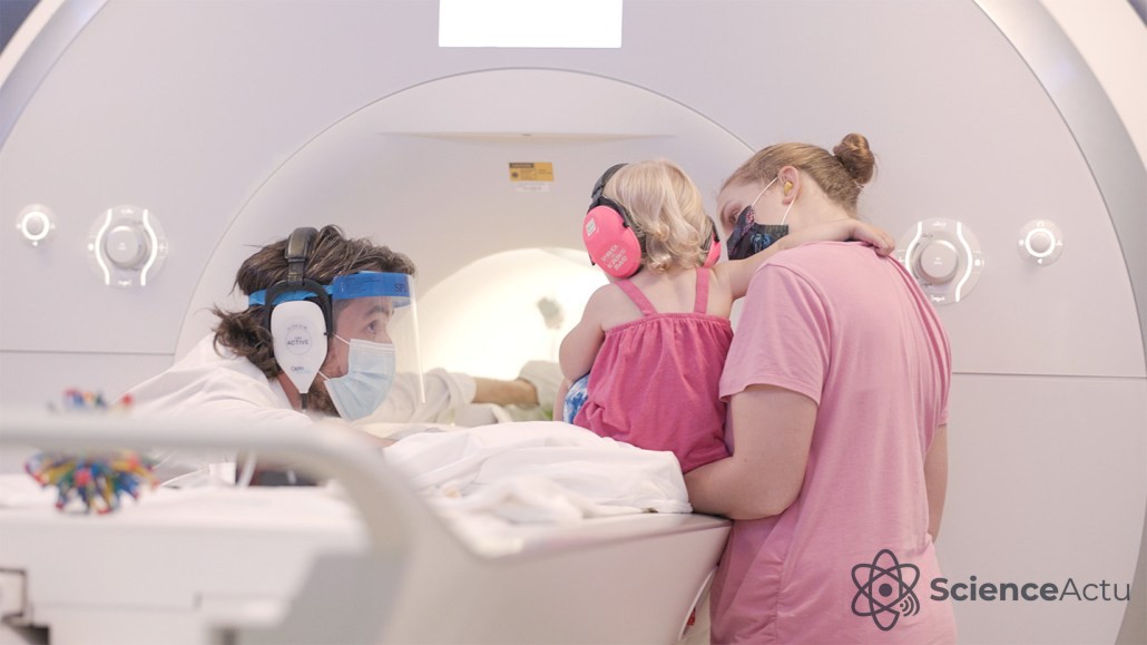 Bébé portant un casque rose préparé pour entrer dans une machine IRM fonctionnelle pour un test de mémoire.