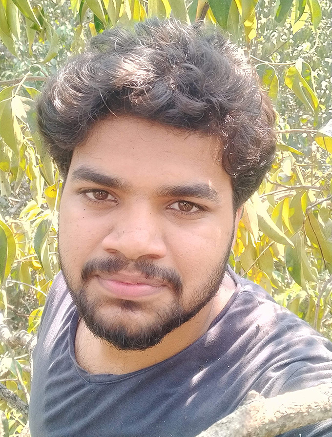 Selfie de l'écologue Akhil Javad au milieu des arbres de la forêt tropicale