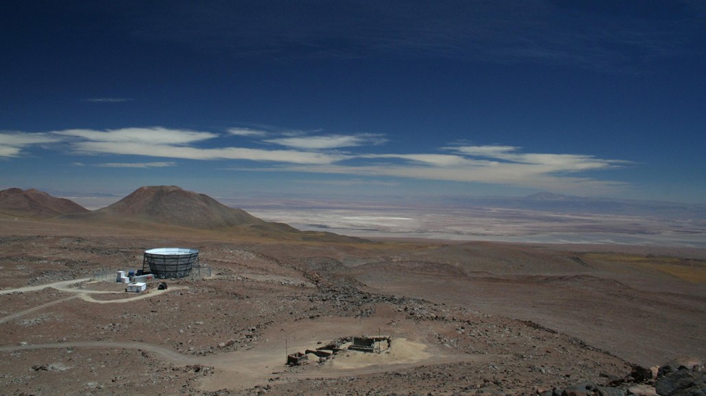 Un observatoire en haute altitude dans le désert d'Atacama au Chili, entouré d'un paysage aride sous un ciel bleu profond.