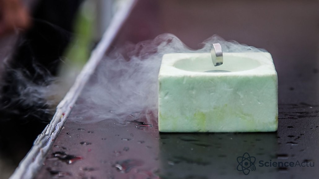 Un aimant cylindrique lévite au-dessus d'un conteneur en polystyrène entouré d'une brume froide