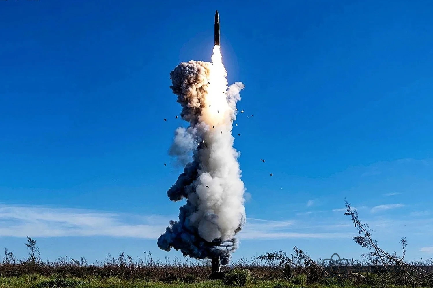 Lancement d'un missile balistique intercontinental avec une traînée de feu et de fumée.