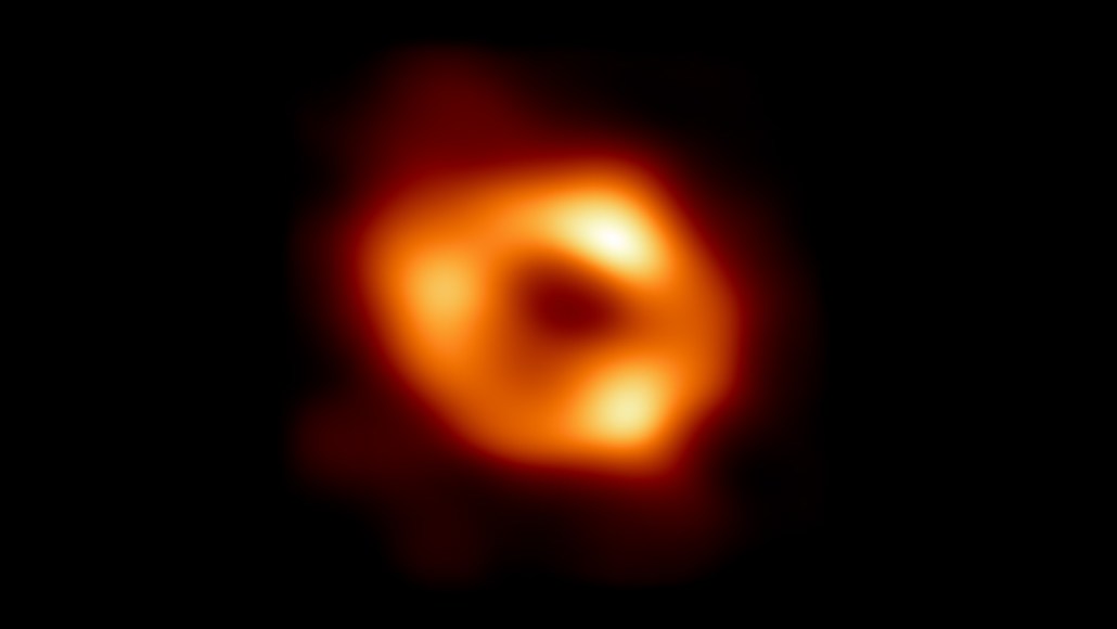 Image d'un trou noir montrant un cercle orange brillant au centre d'un extérieur sombre