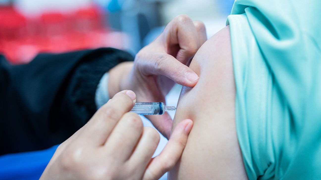 Un professionnel de santé préparant une injection sous-cutanée avec une seringue