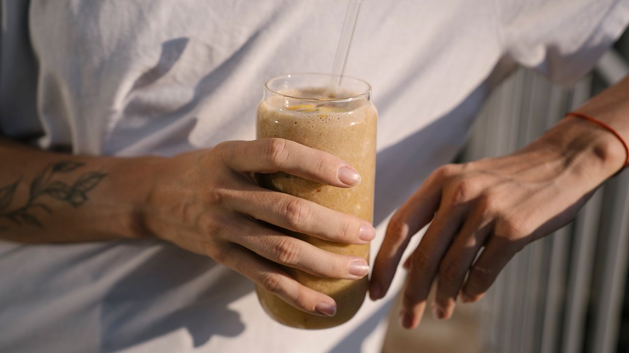 Femme tenant un smoothie protéiné pour réguler sa glycémie