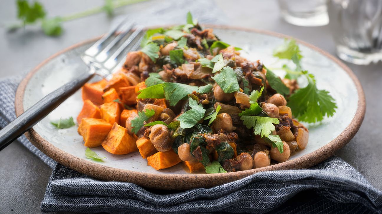 Bol chaud de pois chiches, patates douces et épinards dans une sauce au lait de coco