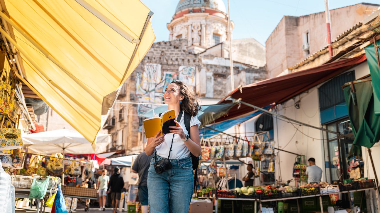 Femme touriste marchant dans un marché tropical, illustrant le voyage avec des traitements médicaux