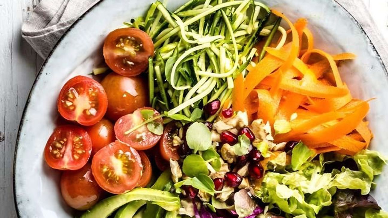 Bol de salade colorée avec vinaigrette aux noix de cajou