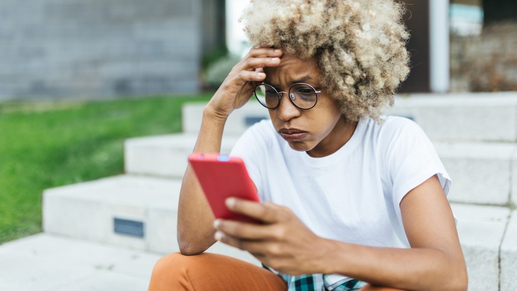 Jeune femme inquiète regardant son téléphone
